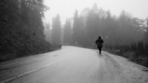 A lone figure walks down a foggy road in a forest in Bolu, Türkiye, creating a mysterious atmosphere.